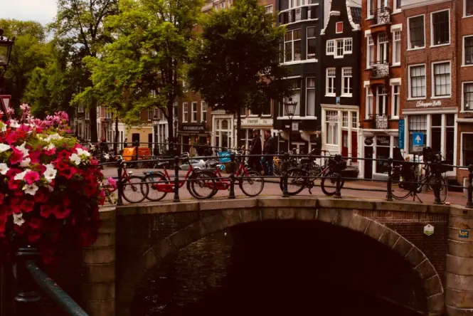 Bicycles parked along an Amsterdam canal bridge