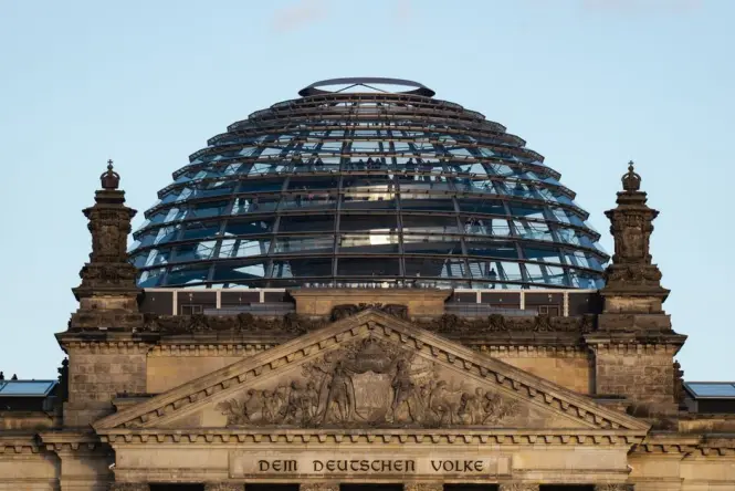 Visitors walking up the spiral ramp inside the modern glass dome of the Reichstag building.