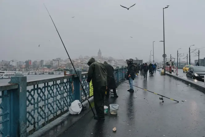 Local fishermen casting lines from the Galata Bridge over the Golden Horn in Istanbul.
