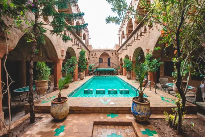 A peaceful courtyard of a traditional Moroccan riad with a tiled plunge pool.