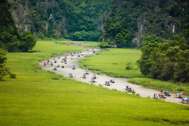 Boat traveling through limestone karsts on the river in Ninh Binh