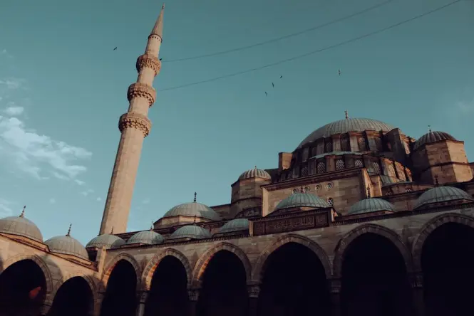 The grand exterior of the Suleymaniye Mosque in Istanbul under a blue sky.