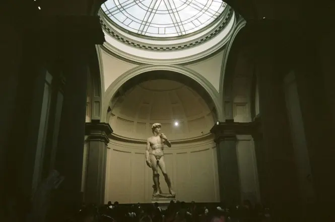 Visitors admiring statues inside the hall of prisoners at the Accademia Gallery