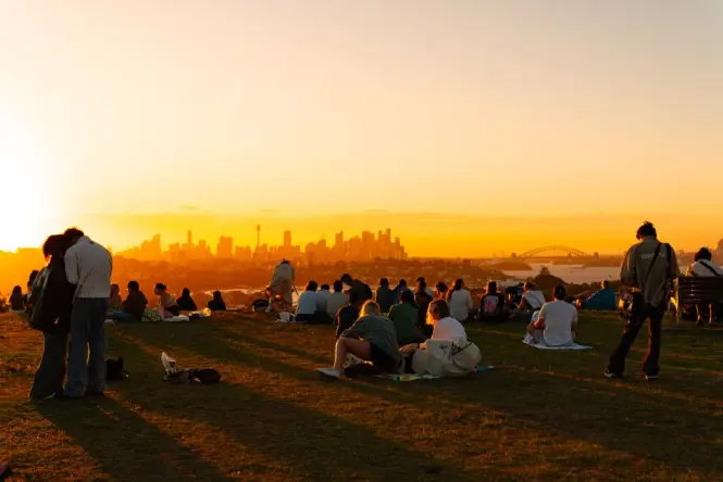 Visitors picnicking on the lawns at Barangaroo Reserve with skyline views