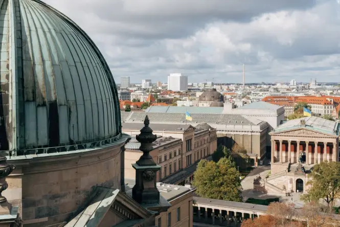 Visitors walking along the outdoor gallery encircling Berlin Cathedral's dome