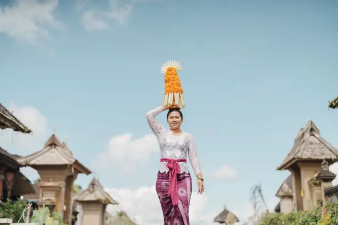 Visitors wearing traditional Balinese sarongs and sashes at a temple entrance
