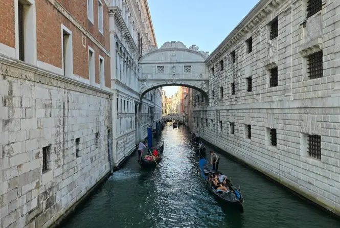A row of gondolas on the water beneath the Bridge of Sighs