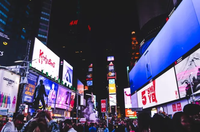Times Square lit up at night with crowds