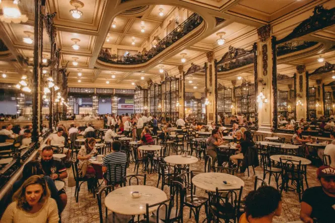 Ornate historic coffeehouse interior with columns and chandelier