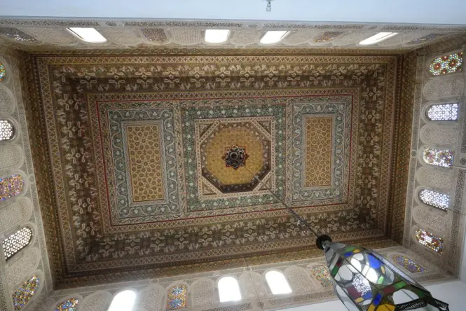 Carved cedar ceiling and stucco details inside a reception salon at Dar El Bacha Museum