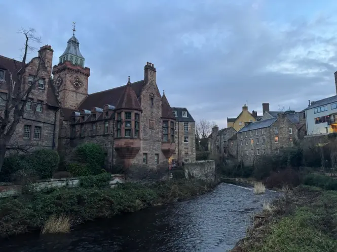 Well Court building with its clock tower reflected in the Water of Leith