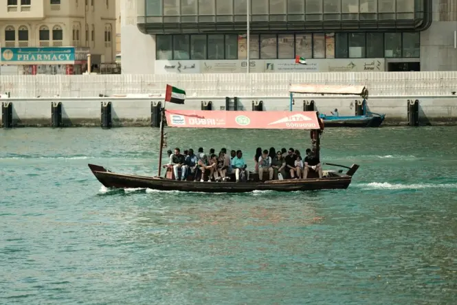 Passengers riding a wooden abra boat across Dubai Creek