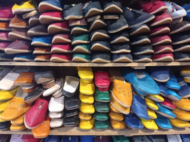 Rows of leather babouche slippers displayed at a Marrakech souk stall