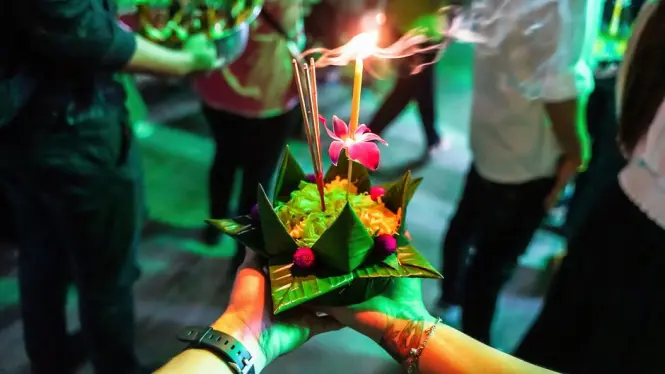Erawan Shrine illuminated at night with offerings