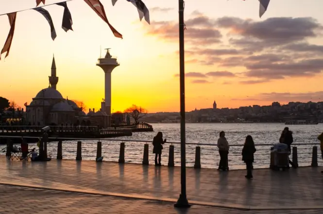 Visitors walking along the Galataport promenade at sunset