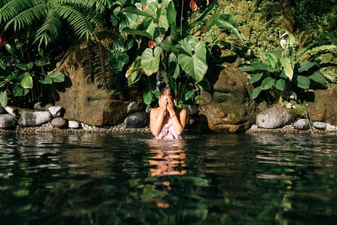 Carved nymph statues pouring water at Goa Gajah's bathing pools
