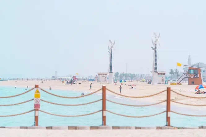 Swimmers wading into the calm shallow waters off Jumeirah Beach