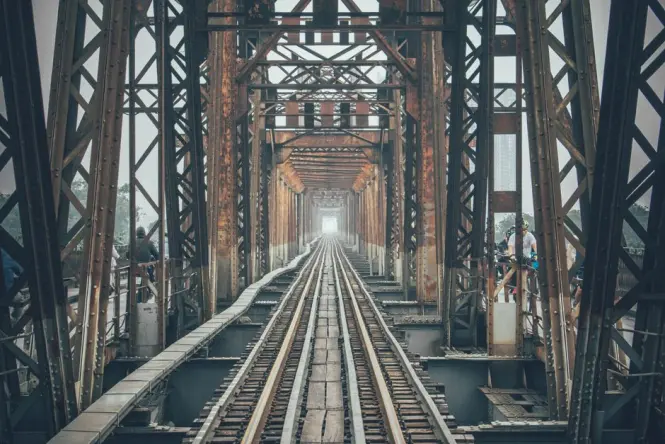 Weathered steel trusses showing the patched history of Long Bien Bridge