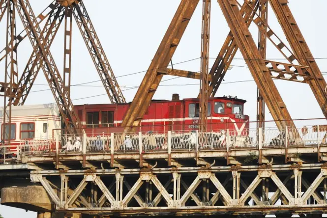 A train crossing the central rail track of Long Bien Bridge