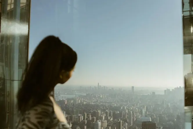 Visitors standing on the glass floor section of Seoul Sky observation deck