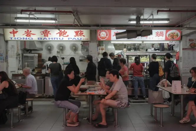 Diners filling tables at a Singapore hawker centre during lunch hour