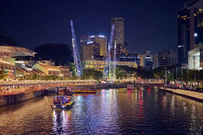A river cruise boat passing Marina Bay near Merlion Park