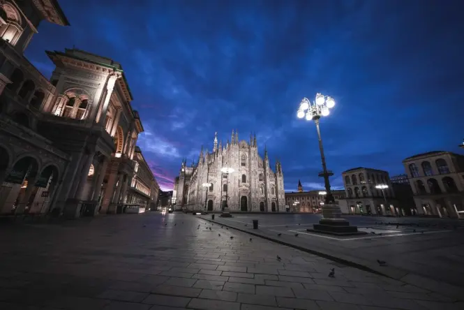 Crowds walking around the open square of Piazza del Duomo in front of the cathedral