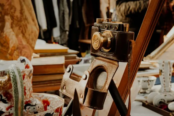 An outdoor display of vintage cameras, old pocket watches, and brass decor at the Sunday market.