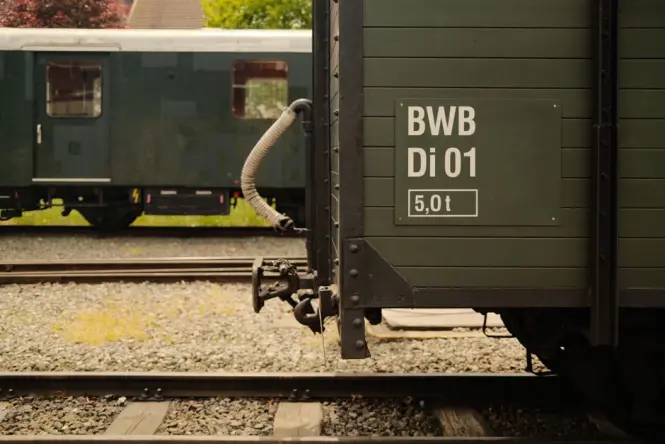 An early 19th century steam carriage on display with historic wooden wheels