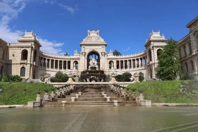 Visitors sitting on the steps of the Palais Longchamp fountain plaza