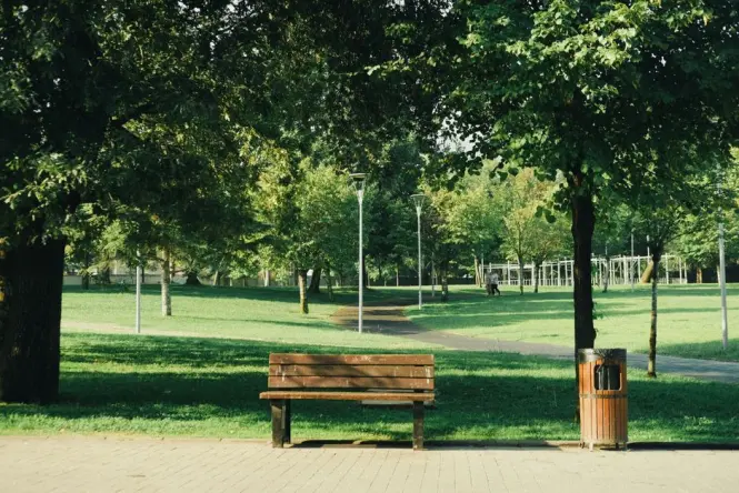 Shaded park path with benches behind Palais Longchamp