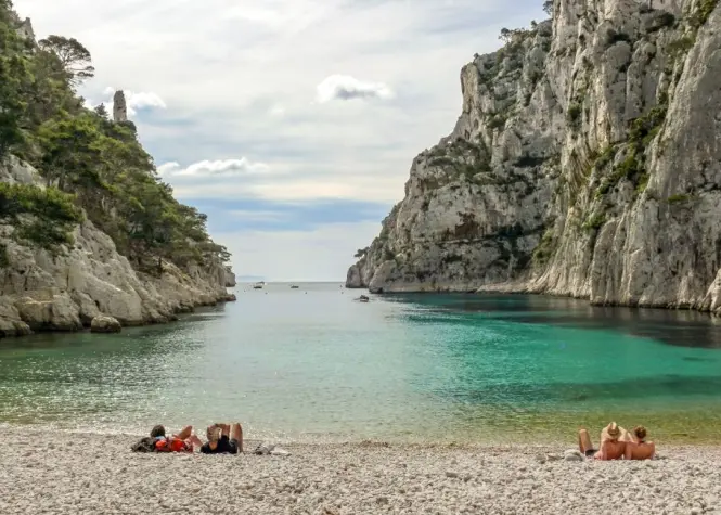 Family swimming in calm shallow water off a beach on the French Riviera