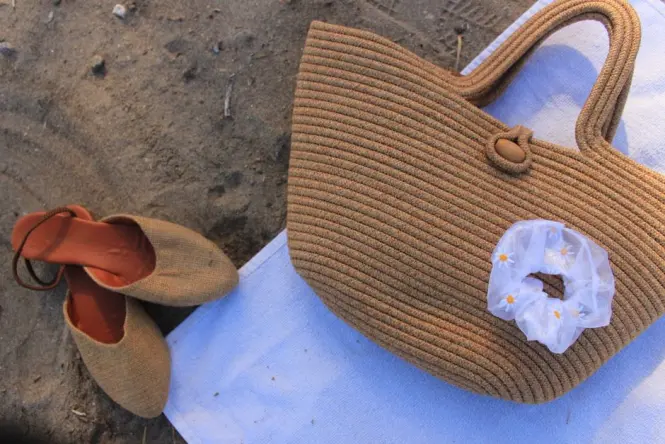 Water shoes and towel on the gravel sand at Prado Beach