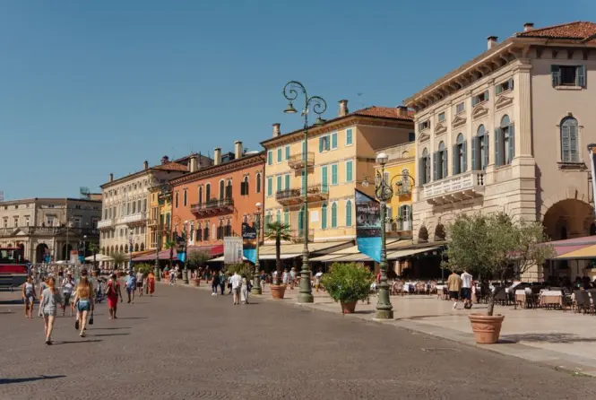 People enjoying wine and food at outdoor tables in Bologna
