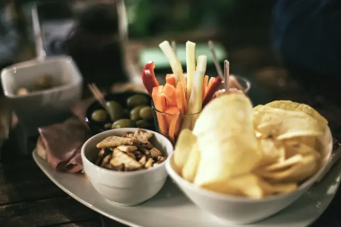 A classic Italian aperitivo spread with drinks and small plates on an outdoor table