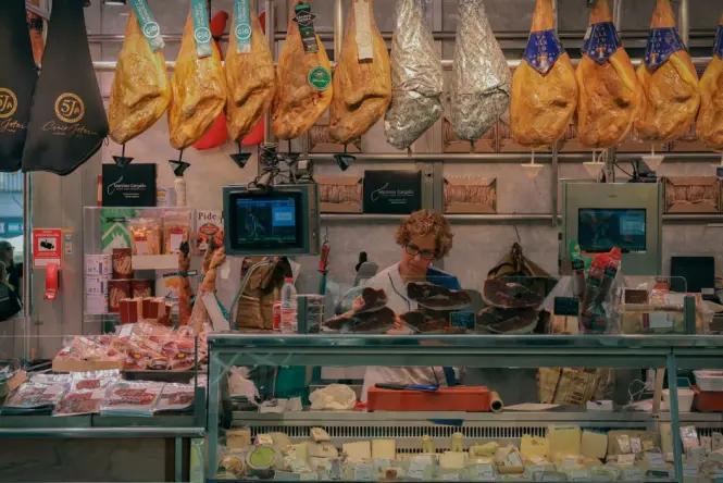 Large rounds of Parmigiano Reggiano displayed inside a traditional food shop