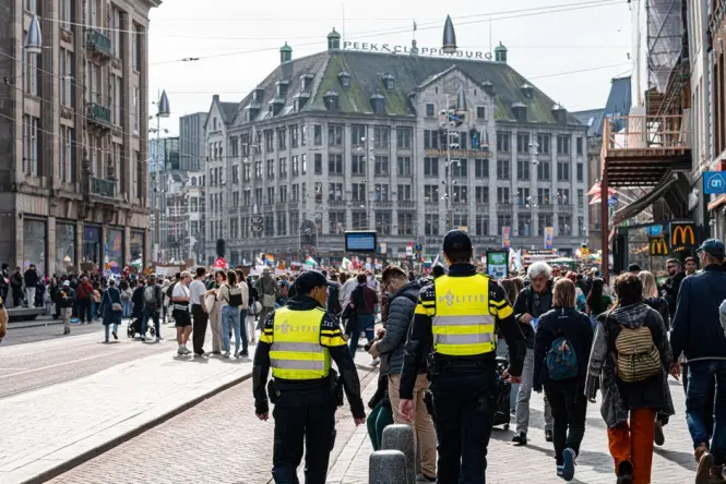 A wide view of bustling Dam Square in front of the Royal Palace in Amsterdam