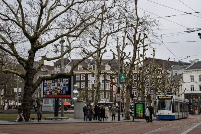 A blue and white tram stopping near Dam Square in Amsterdam