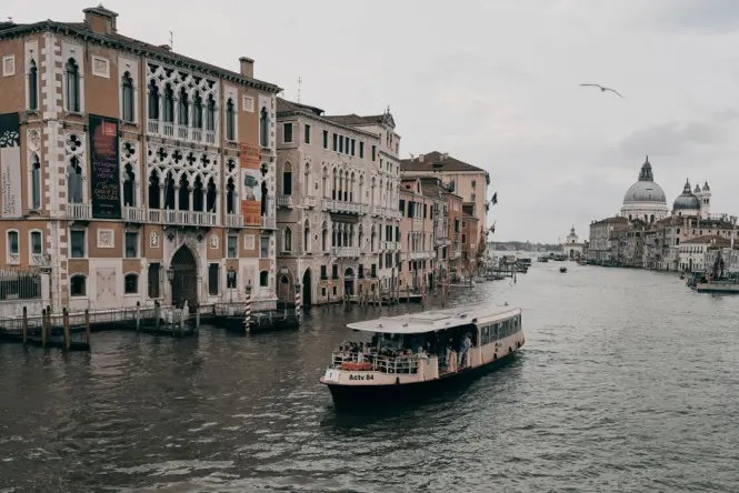A classic Venetian vaporetto water bus heading towards the Salute station