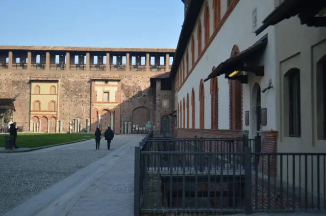 Walking through the stone archways of Sforza Castle Milan