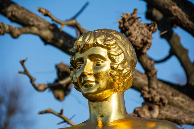 Close-up of the gilded bronze Johann Strauss statue in Vienna's Stadtpark