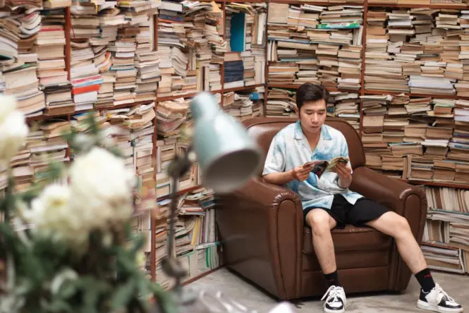 Visitor reading a book at a table inside Starfield Library