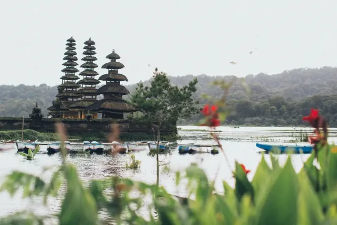 Wooden rowboat docked at the jetty near Ulun Danu Beratan Temple on Lake Bratan
