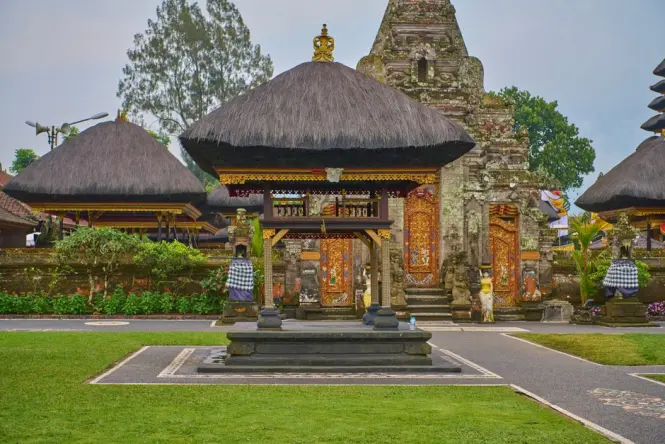 Manicured topiary garden and stone gateway on the grounds of Ulun Danu Beratan Temple