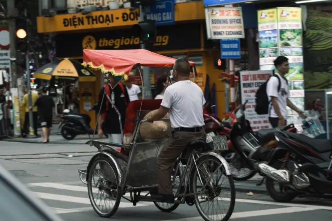 Taxis driving along a busy street in Hanoi, illustrating the typical ride-hailing journey to Cau Giay.
