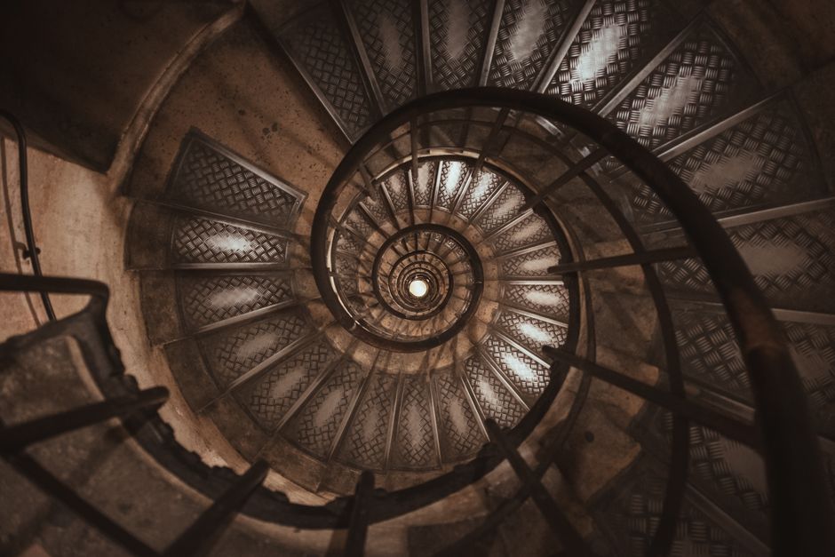 Spiral staircase descending into the Paris Catacombs